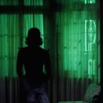 Silhouette d’une femme devant un éclairage vert à La maison du cinéma Toulouse.