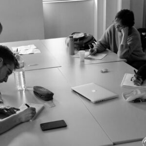 Réunion de groupe autour d'une table avec ordinateurs et papiers. La maison du cinéma Toulouse.