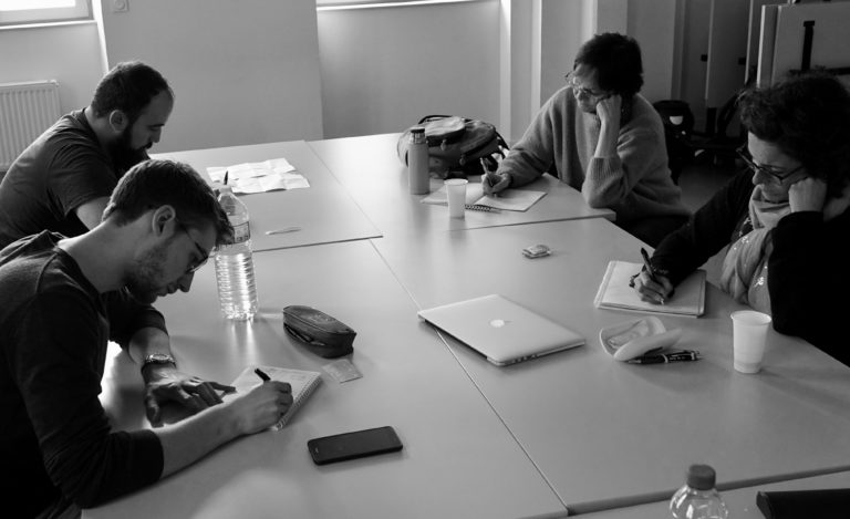 Réunion de groupe autour d'une table avec ordinateurs et papiers. La maison du cinéma Toulouse.