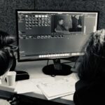 Deux personnes regardant un écran d'ordinateur avec un logiciel de montage vidéo. La maison du cinéma Toulouse.